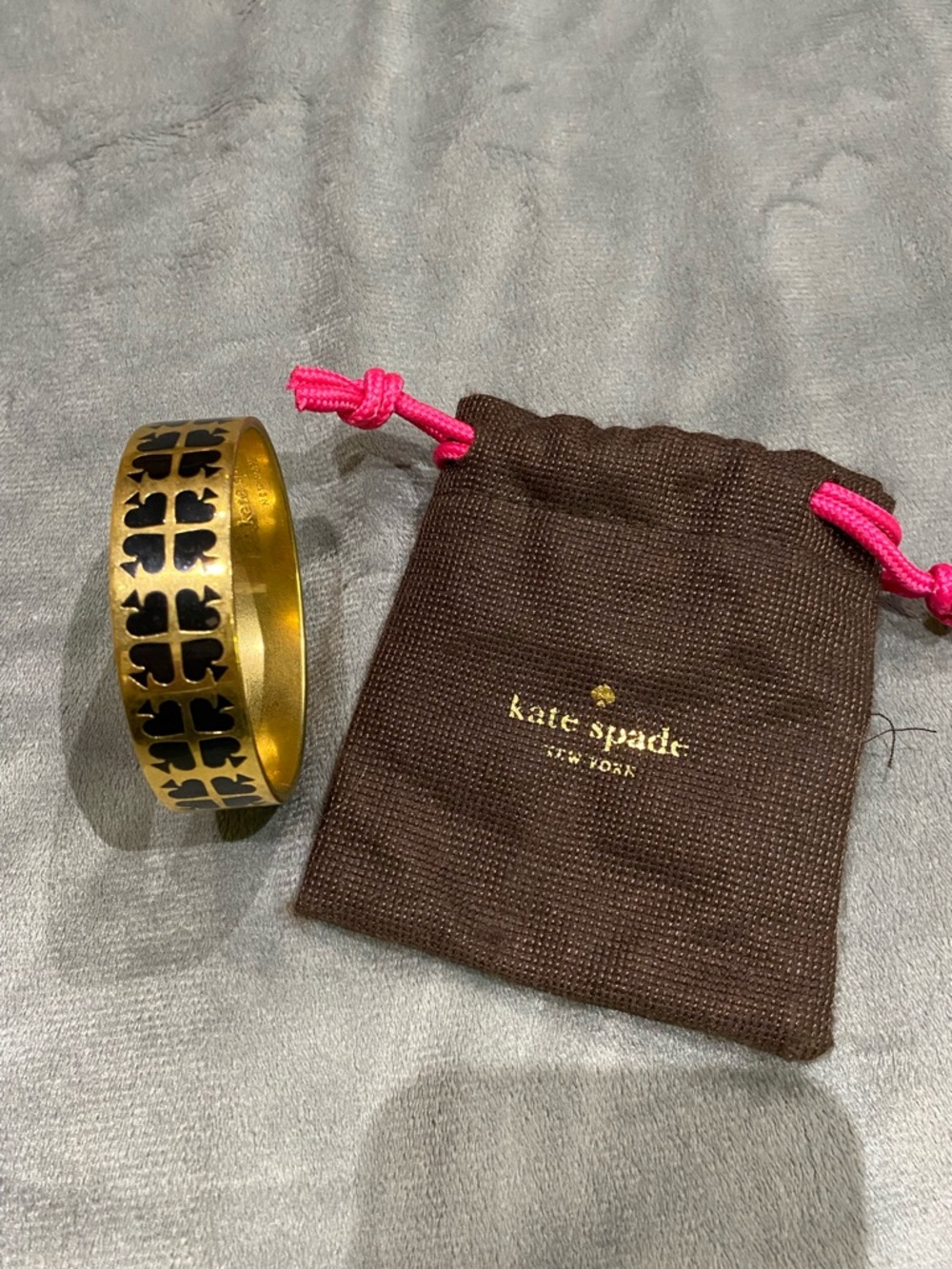 kate spade gold and black cutout logo bangle with pouch